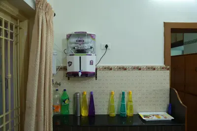 a kitchen counter with a coffee maker on the wall at Coimbatore Home Stay & Serviced Apartment in Coimbatore