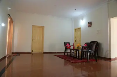 a room with chairs and a table in it at Coimbatore Home Stay & Serviced Apartment in Coimbatore