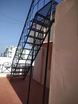 a metal spiral staircase on the side of a building at Coimbatore Home Stay & Serviced Apartment in Coimbatore