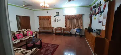 a living room with couches and a table and chairs at Coimbatore Home Stay & Serviced Apartment in Coimbatore