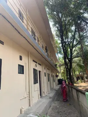 a woman walking down a sidewalk next to a building at Airavatham Apartments in Guruvāyūr