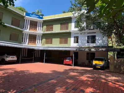 a building with cars parked in front of it at Airavatham Apartments in Guruvāyūr