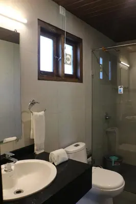 a bathroom with a sink and a toilet and a window at Logan Camp Ooty in Coonoor