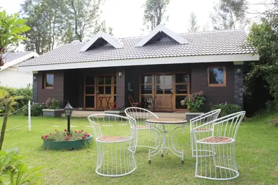 a group of chairs and a table in front of a house at Logan Camp Ooty in Coonoor
