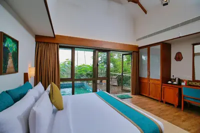 a bedroom with a large bed and a large window at Morickap Resort in Vythiri