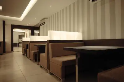 a row of chairs and tables in a restaurant at Hotel Merlin International in Trichūr