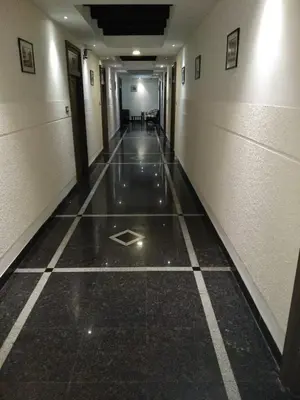 an empty hallway with ailed floor in a building at Hotel Merlin International in Trichūr