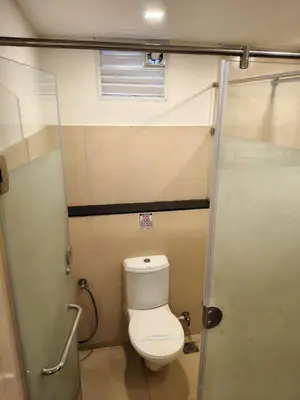 a small bathroom with a toilet and a shower at Hotel Merlin International in Trichūr