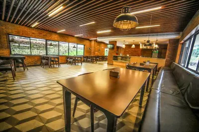 a restaurant with tables and chairs in a room at Hotel Villa Maryam in Kozhikode