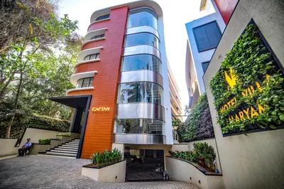a building with a person sitting in front of it at Hotel Villa Maryam in Kozhikode