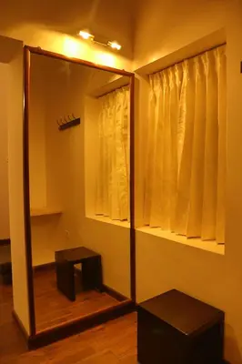 a mirror and a stool in a room at The Tamarillo in Ooty