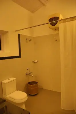 a bathroom with a toilet and a shower at The Tamarillo in Ooty