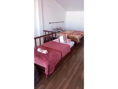 two beds in a room with wooden floors at The Views - True Baduaga Living in Ooty