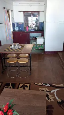 a kitchen with a wooden table and stools at The Views - True Baduaga Living in Ooty