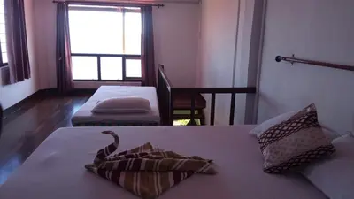 a living room with two beds and a window at The Views - True Baduaga Living in Ooty