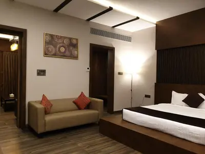 a hotel room with a bed and a couch at D Wayfarer Inn Resort in Erode