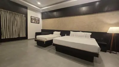 a hotel room with two beds and a lamp at D Wayfarer Inn Resort in Erode