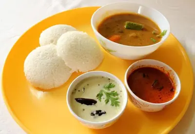a plate of food with soup and bread and dip at Kunnampath Heritage Nalukettu in Trichūr