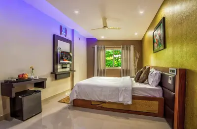 a bedroom with a bed and a window with purple lights at ALSHIFA TBG RESIDENCY in Perintalmanna