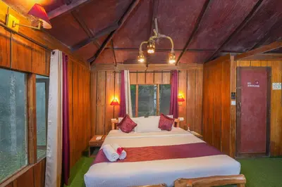 a bedroom with two beds in a room with wooden walls at Nature Zone Jungle Resort- Experience the Wilderness & Adventure in Munnar