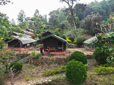 two people standing in front of a black tent at Nature Zone Jungle Resort- Experience the Wilderness & Adventure in Munnar
