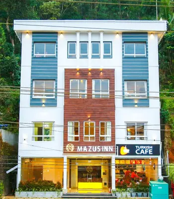 a white and blue building with a store at MAZUS INN in Vythiri