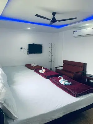 a bedroom with a white bed with a ceiling at Deluxe Residency in Kalpetta