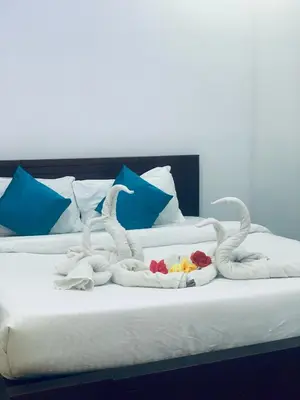 a bed with two swans made out of towels at Deluxe Residency in Kalpetta