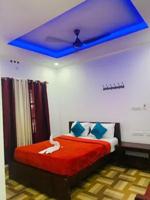 a bedroom with a bed with a blue ceiling at Deluxe Residency in Kalpetta
