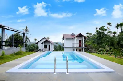a swimming pool in front of a house at Le Eden Premium Wayanad Pool Resort in Sultan Bathery
