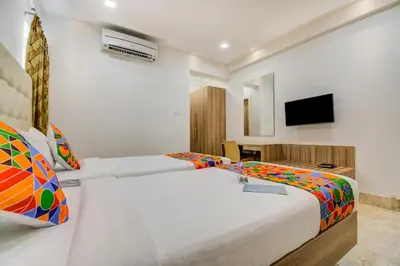 a bedroom with two beds and a flat screen tv at Park Avenue Suites in Coimbatore