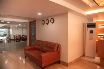 a living room with a couch and clocks on the wall at Park Avenue Suites in Coimbatore