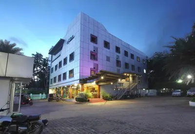 a large white building with a parking lot in front at Park Residency Airport Road in Kozhikode