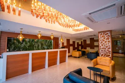 a lobby with chairs and a bar with chandeliers at JK HOTELS in Coimbatore