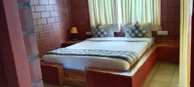 a bedroom with a bed in a brick wall at The Realm in Coonoor