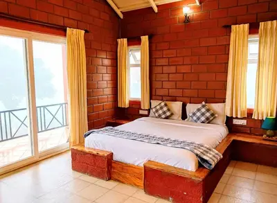 a bedroom with a bed in a room with windows at The Realm in Coonoor
