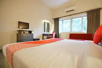 a hotel room with a large bed and a window at Townhouse Mookkannoor Tourist Home in Cochin
