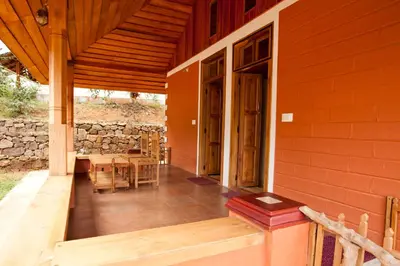 a porch of a house with a table and chairs at Kabbe Holidays in Madikeri