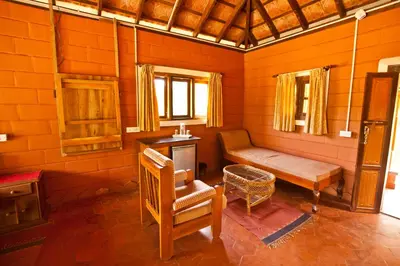 a room with a bench and a table and a chair at Kabbe Holidays in Madikeri