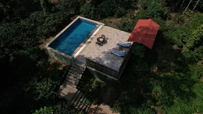 an overhead view of a swimming pool with a table at Machaan Wilderness Lodge Nagarahole in Srimangala