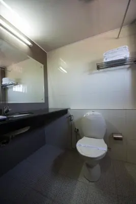 a bathroom with a toilet and a sink and a mirror at Kallada Hotels and Resorts in Trichūr