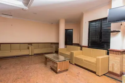 a waiting room with couches and a flat screen tv at Kallada Golden Hotel in Trichūr