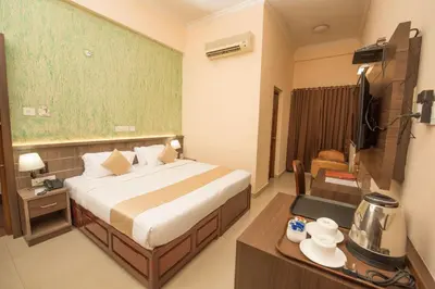 a hotel room with a bed and a table with a table at Kallada Golden Hotel in Trichūr