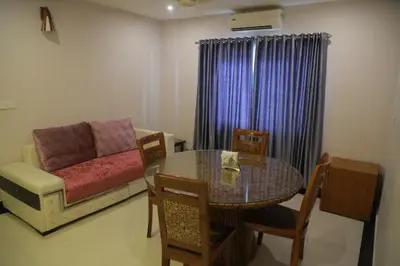 a living room with a table and a couch at Hotel Jyothis Regency in Palakkad
