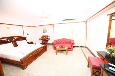 a bedroom with a bed and a couch and a table at Mayura Residency in Guruvāyūr