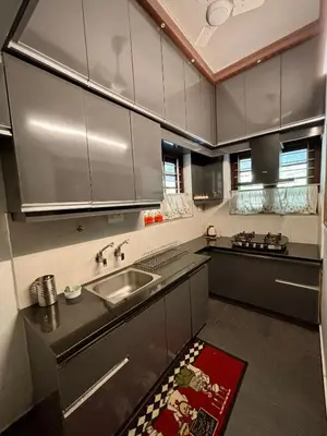 a kitchen with stainless steel cabinets and a sink at Gloria Homestay ,Thrissur - Pooram Bookings open Apr 25-27 in Trichūr