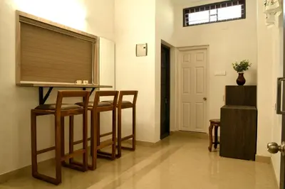 a room with a bar with chairs and a window at Gloria Homestay ,Thrissur - Pooram Bookings open Apr 25-27 in Trichūr