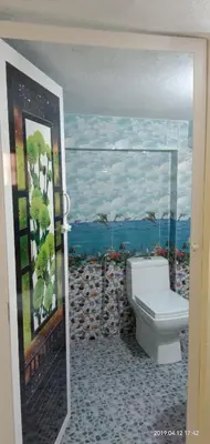 a bathroom with a toilet and a painting on the wall at Coorg Homeland Homestay -With Kitchenette in Madikeri