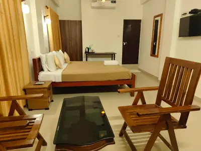 a bedroom with a bed and a table and chairs at Oxxon Airport Hotel in Angamali