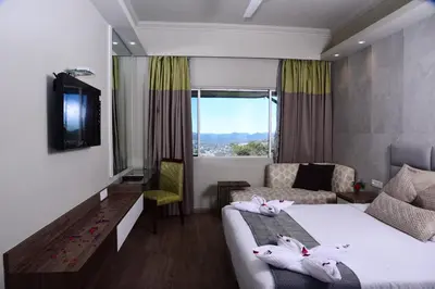 a hotel room with a bed and a couch at Sinclairs Retreat Ooty in Ooty